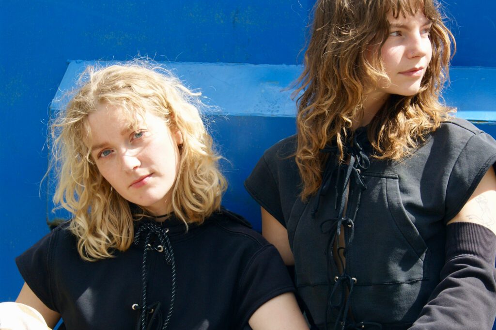 Modeller iført PATAKOs bæredygtige sorte Pearl Hoodies og ærmer - upcyclet i hånden og lavet af genbrugsmaterialer