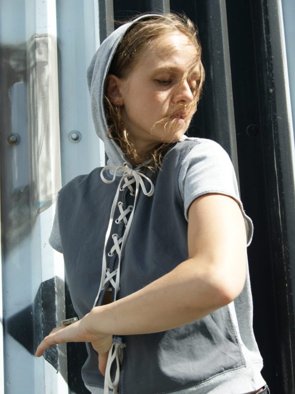 Model bevæger sig i PATAKO STUDIOS upcyclede grå hoodie med bindefunktion